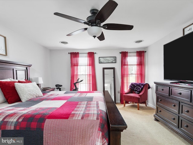 carpeted bedroom featuring multiple windows and ceiling fan