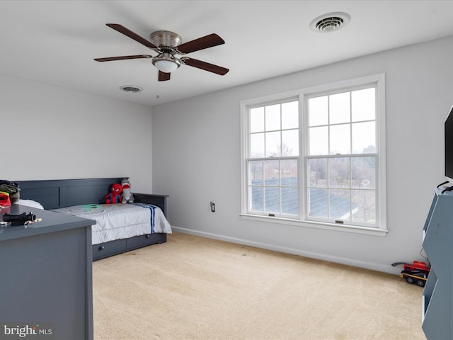 carpeted bedroom featuring multiple windows and ceiling fan