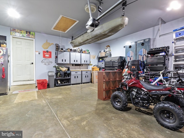 garage featuring a garage door opener and stainless steel refrigerator