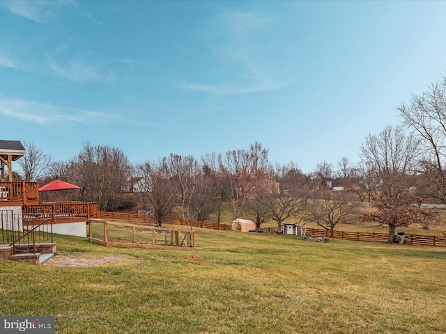 view of yard featuring a storage shed, a rural view, and a deck