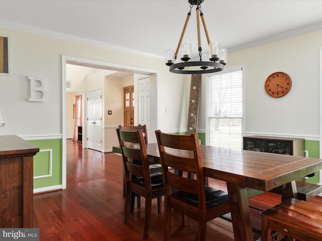 dining space with an inviting chandelier, dark wood-type flooring, and ornamental molding