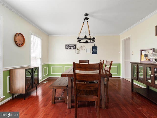 dining area featuring dark hardwood / wood-style floors, ornamental molding, and a chandelier