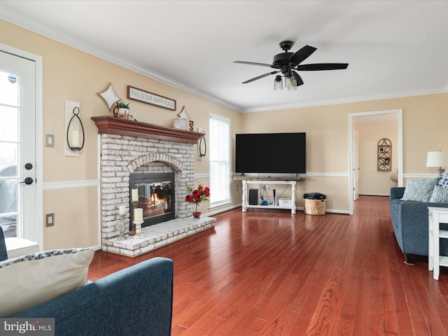 living room with a fireplace, wood-type flooring, ceiling fan, and ornamental molding