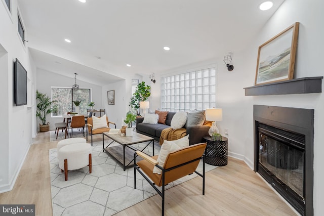 living room with lofted ceiling and light hardwood / wood-style flooring