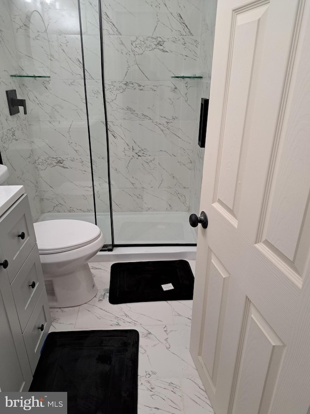 bathroom with vanity, toilet, and a shower with shower door