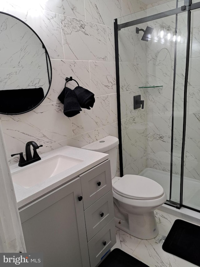 bathroom featuring vanity, toilet, walk in shower, and tile walls