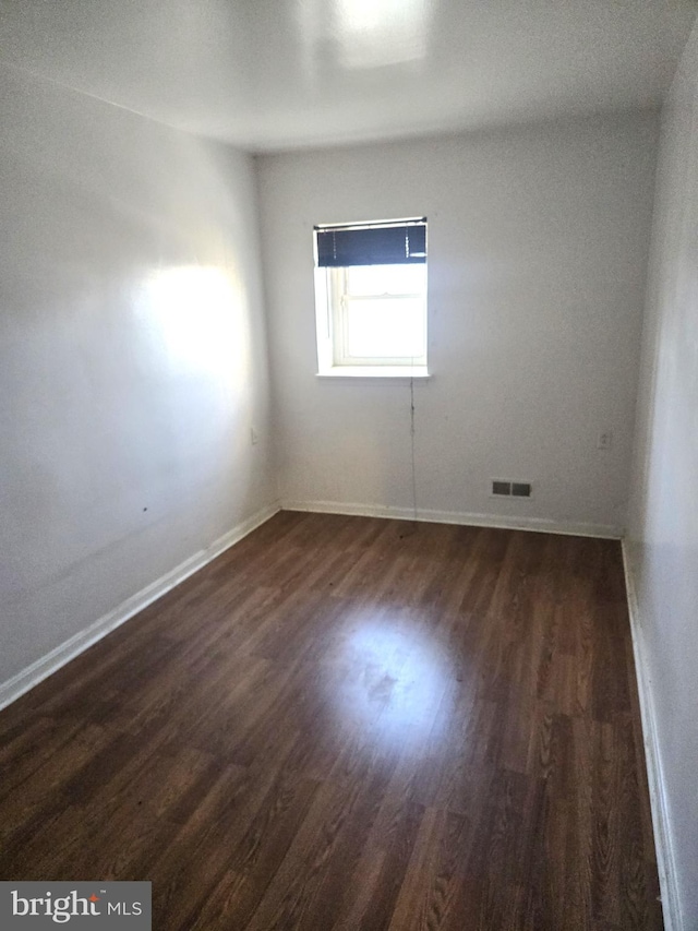 unfurnished room featuring dark hardwood / wood-style flooring