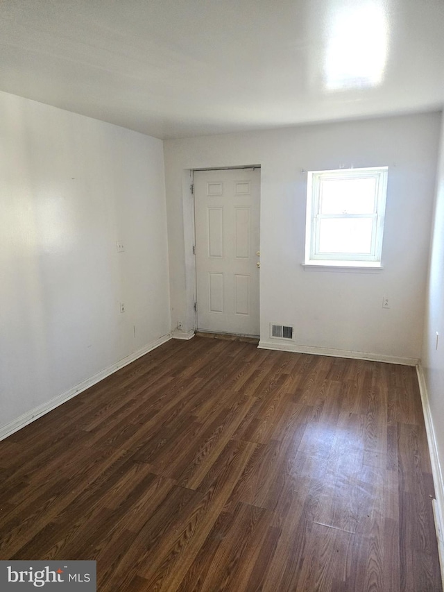 empty room featuring dark hardwood / wood-style flooring