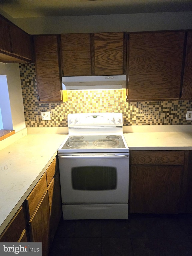 kitchen featuring electric range oven and backsplash