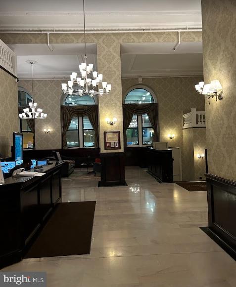 interior space with crown molding, pendant lighting, and a notable chandelier