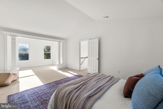 carpeted bedroom with lofted ceiling