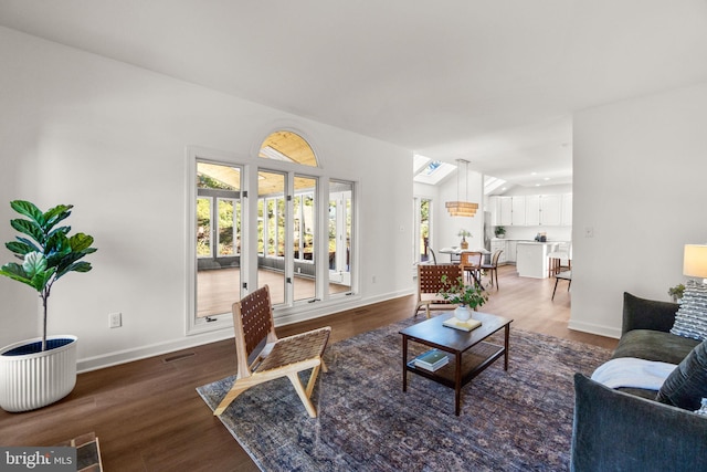 living room featuring dark hardwood / wood-style flooring, vaulted ceiling, and plenty of natural light