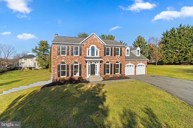 colonial house with a front yard and a garage