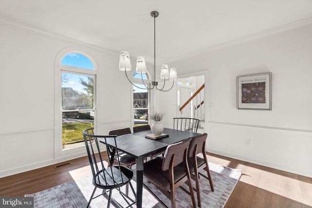 dining room featuring ornamental molding, dark wood-type flooring, and a notable chandelier