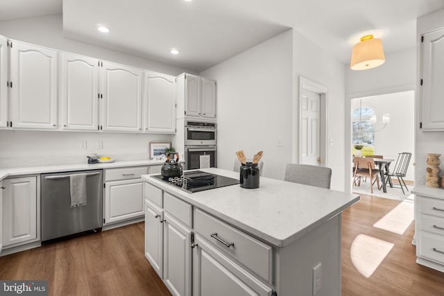 kitchen featuring dark hardwood / wood-style floors, a center island, white cabinetry, and stainless steel appliances