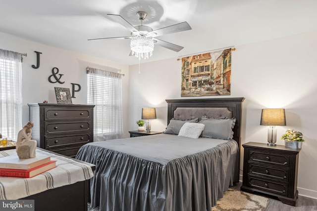 bedroom with ceiling fan, light hardwood / wood-style flooring, and multiple windows