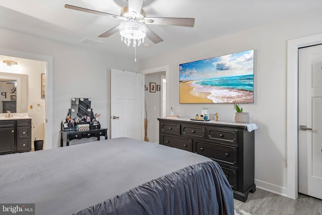 bedroom featuring ensuite bath, ceiling fan, sink, and light hardwood / wood-style floors