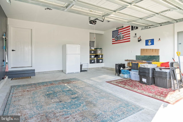 garage featuring white refrigerator and a garage door opener