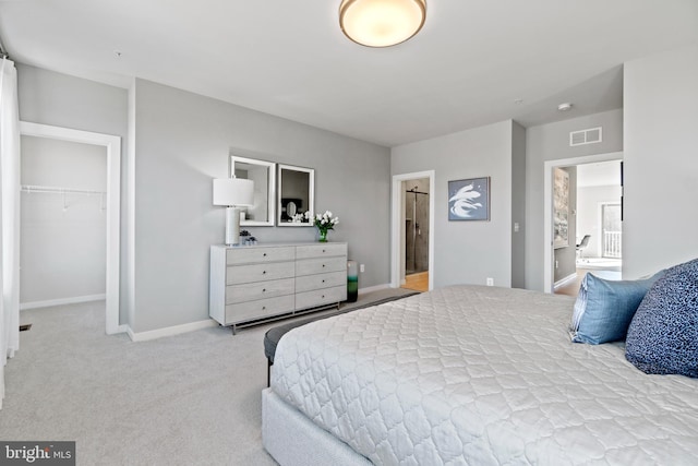 carpeted bedroom with connected bathroom, a spacious closet, and a closet