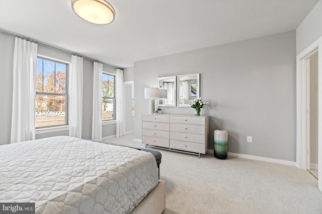 bedroom with light carpet and multiple windows