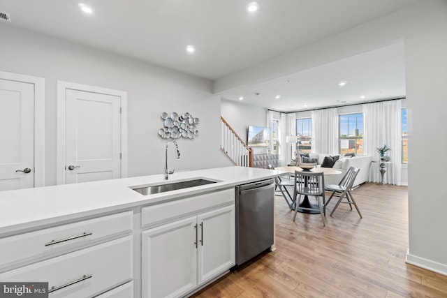 kitchen with dishwasher, sink, white cabinets, and light wood-type flooring