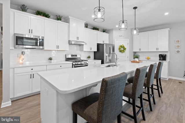 kitchen featuring a kitchen bar, a large island, sink, and appliances with stainless steel finishes