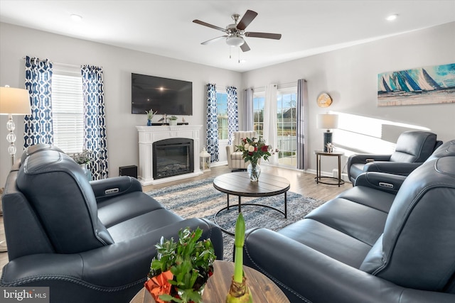 living room with ceiling fan, light hardwood / wood-style flooring, and plenty of natural light