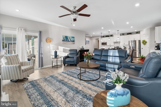 living room with ceiling fan and light hardwood / wood-style floors