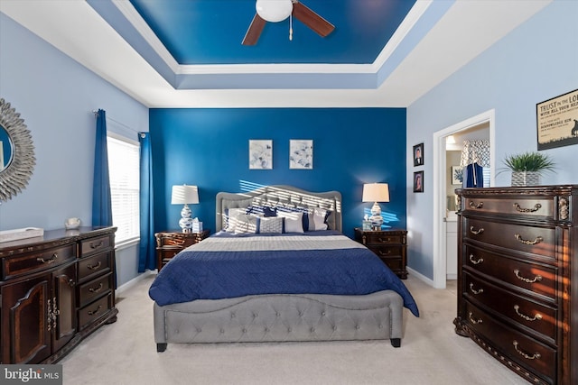 carpeted bedroom featuring ceiling fan and a raised ceiling