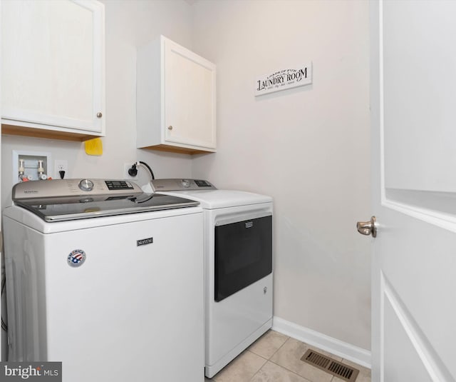 laundry area with separate washer and dryer, light tile patterned flooring, and cabinets