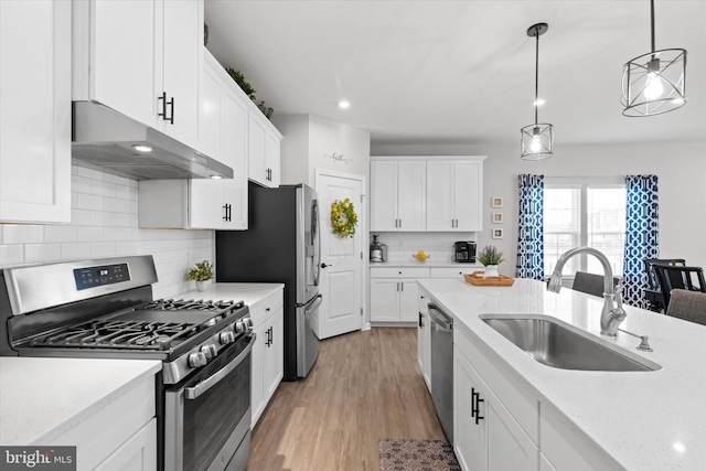 kitchen with pendant lighting, white cabinets, sink, and stainless steel appliances