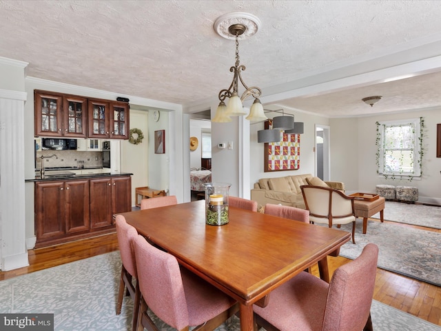 dining area featuring a textured ceiling, a chandelier, and light hardwood / wood-style flooring