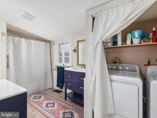 bathroom featuring washing machine and clothes dryer, vanity, and lofted ceiling