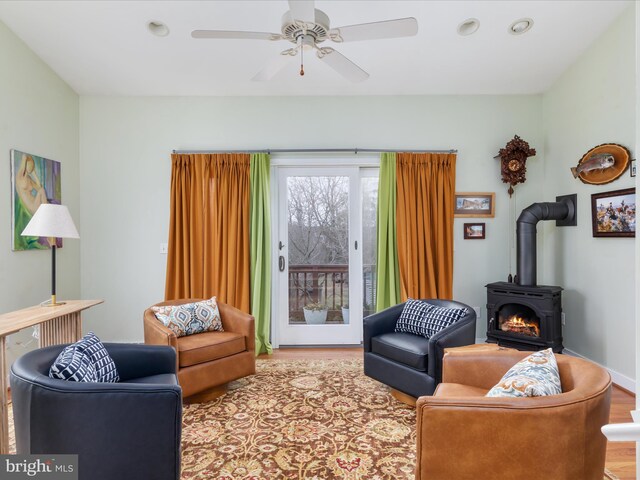 living room with ceiling fan and a wood stove