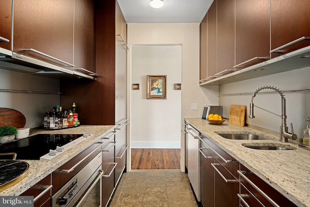 kitchen with light stone counters, sink, and appliances with stainless steel finishes