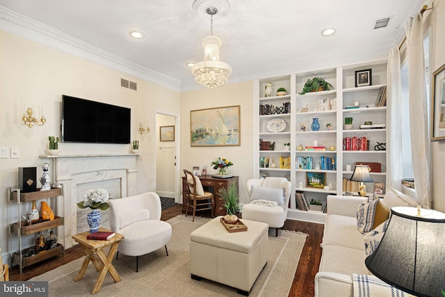 living area with a notable chandelier, a fireplace, wood-type flooring, and ornamental molding