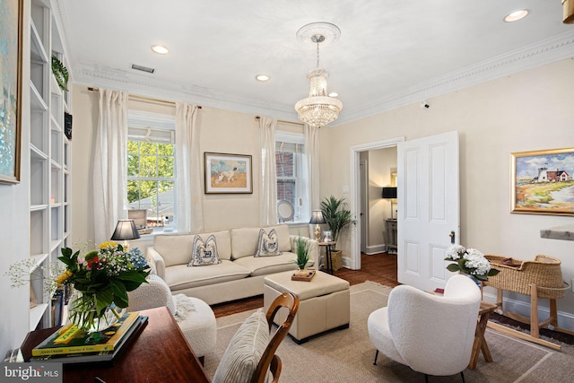 living room with an inviting chandelier and crown molding