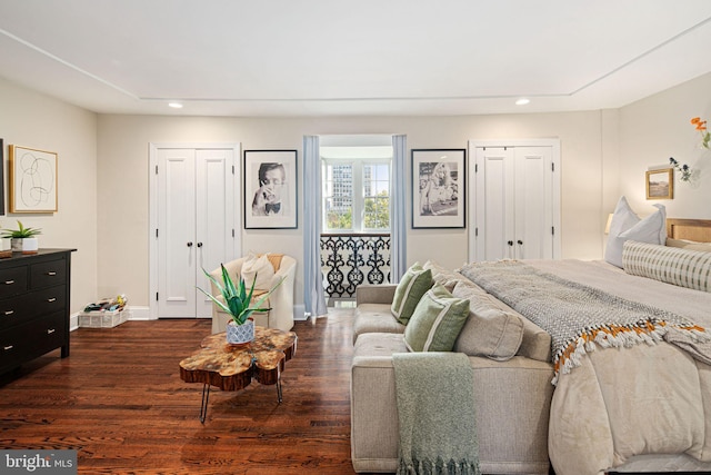 bedroom featuring multiple closets and dark hardwood / wood-style floors