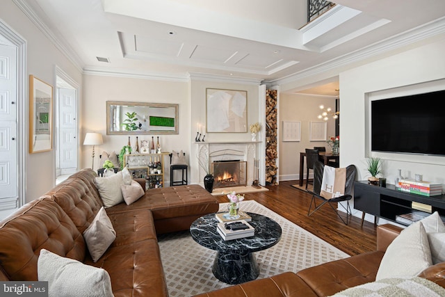 living room with hardwood / wood-style floors, a high end fireplace, a notable chandelier, and ornamental molding