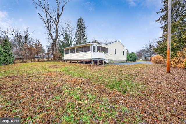 rear view of house featuring a sunroom