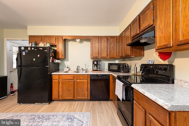 kitchen with sink, black appliances, and light hardwood / wood-style flooring