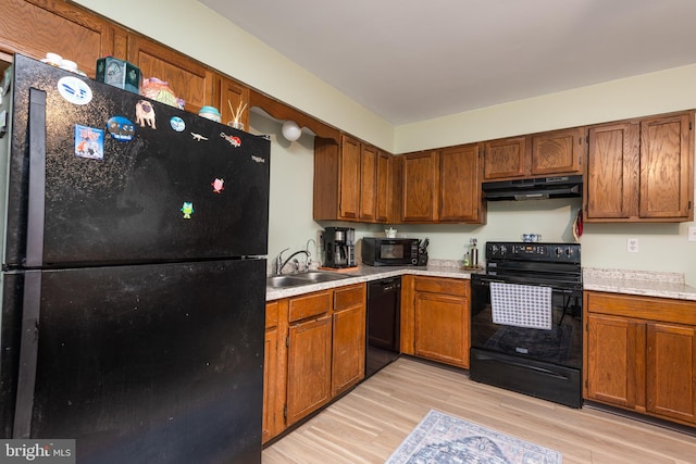 kitchen with light hardwood / wood-style flooring, black appliances, and sink