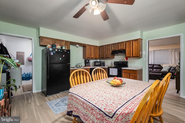 dining space with light wood-type flooring, ceiling fan, and sink