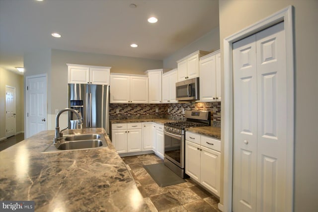 kitchen featuring backsplash, sink, white cabinets, and appliances with stainless steel finishes