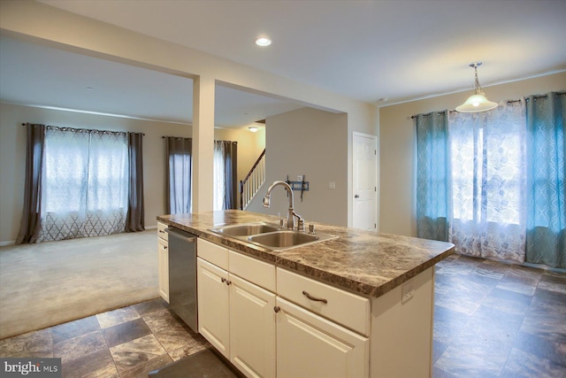 kitchen featuring dark carpet, sink, dishwasher, white cabinetry, and an island with sink