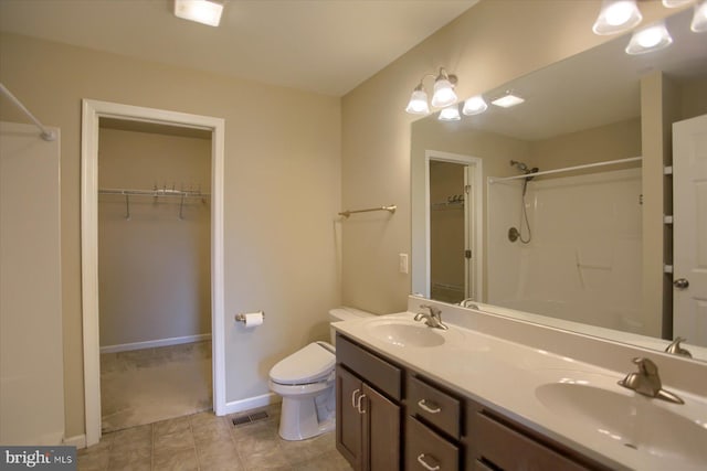 bathroom with a shower, vanity, and toilet