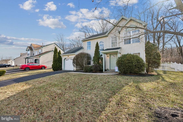 view of property featuring a garage and a front lawn