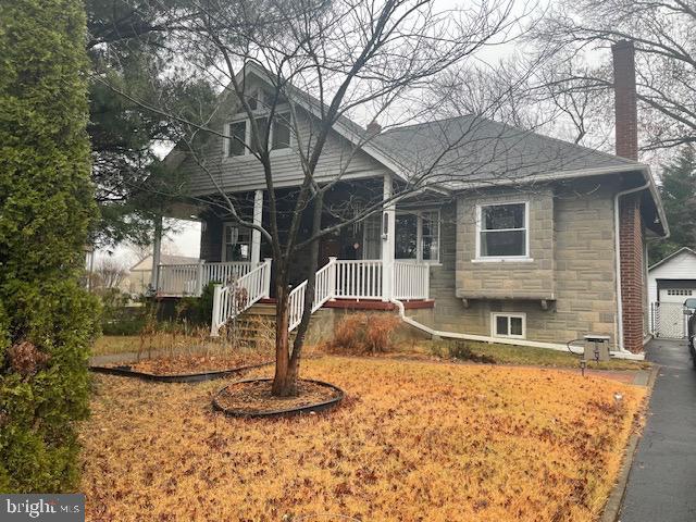 view of front facade featuring an outbuilding, a garage, and covered porch