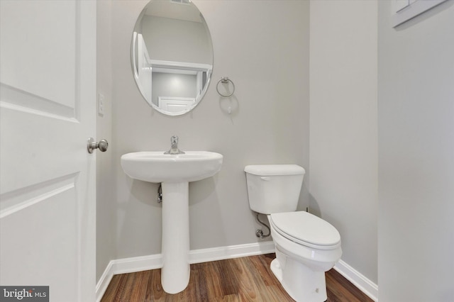 bathroom featuring hardwood / wood-style floors and toilet