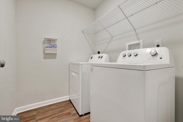 laundry area with separate washer and dryer and wood-type flooring